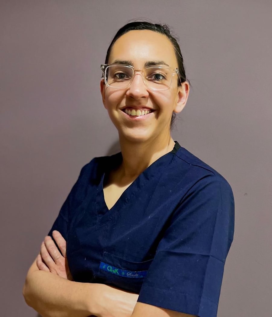 Profissional da área da saúde sorrindo, com uniforme azul-marinho